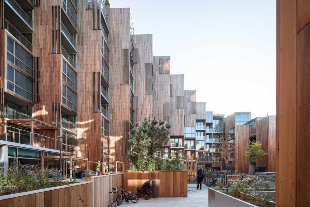 Holzfassade, bepflanzte Terrassen, begrünte Dächer und ein integrierter Kindergarten – das Projekt „79&PARK“ von Bjarke Ingels im Nordosten von Stockholm vereint vereint ländliche Qualitäten und stätidsches Wohngefühl.