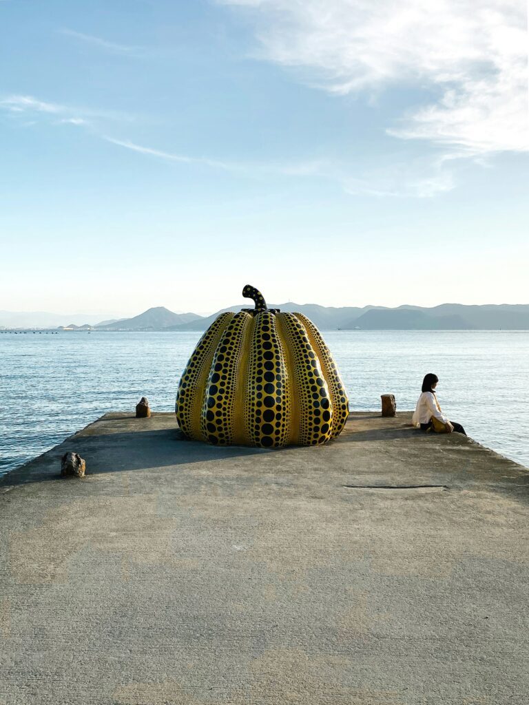 Yayoi Kusamas ikonische Kürbis-Skulptur auf Naoshima – ein leuchtendes Wahrzeichen der Art Island und Symbol für die Verbindung von Natur und zeitgenössischer Kunst.